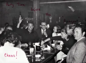 Ein winkender Sean Connery in der Bar des „Hotel Bergidyll“. Der Herr ganz rechts ist Spezialeffekte-Mann John Stears – er doubelt nebenbei den nicht anwesenden Gert Fröbe und wird später zwei Oscars gewinnen – für „Feuerball“ und für „Krieg der Sterne“. Foto: Famile Holzhauser / Steidl Verlag